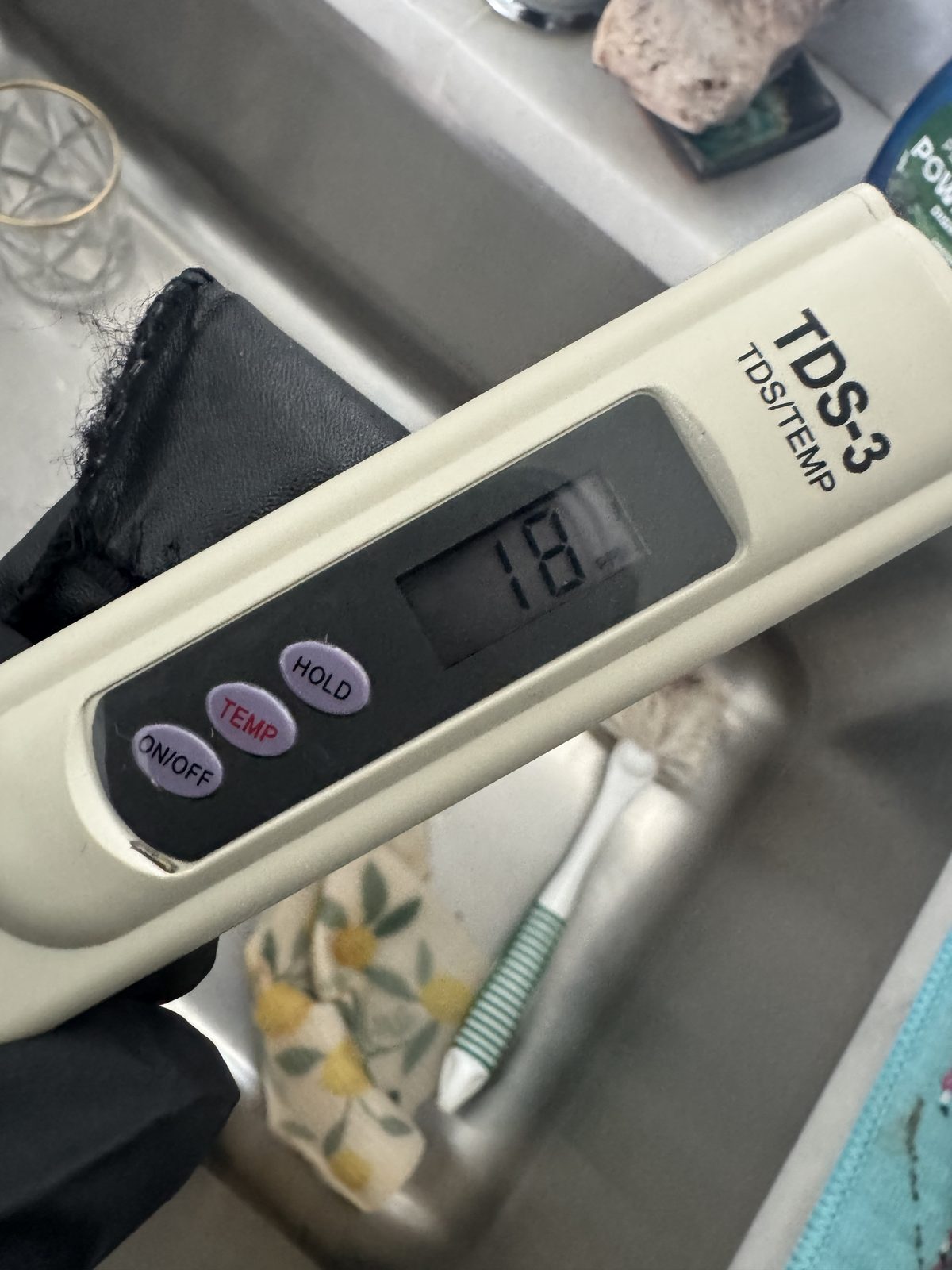 Handheld TDS meter measuring total dissolved solids during an on-site water quality test in Cape Coral, FL.