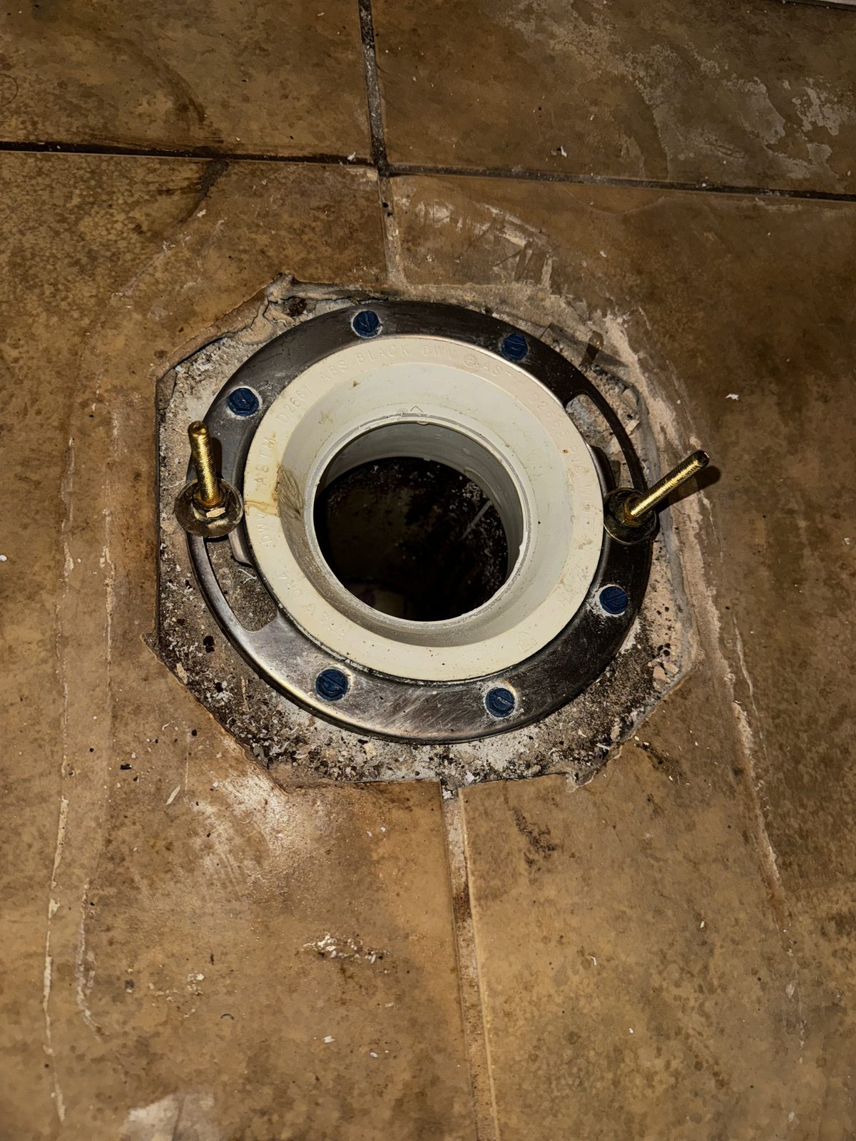 Toilet closet flange exposed on the bathroom floor during a toilet repair in Cape Coral, FL.