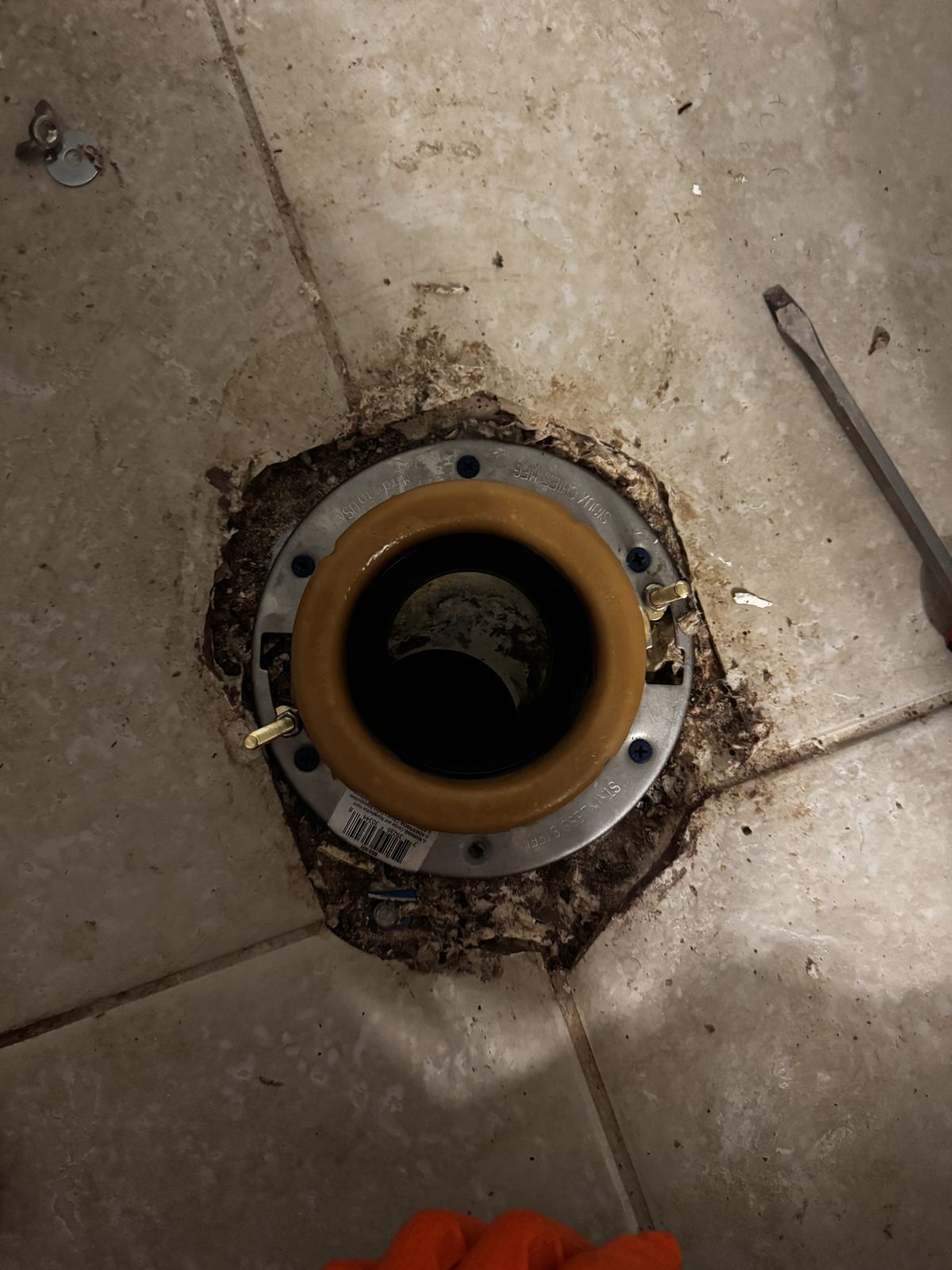 New stainless toilet flange and wax ring set before resetting a toilet in Cape Coral, FL.